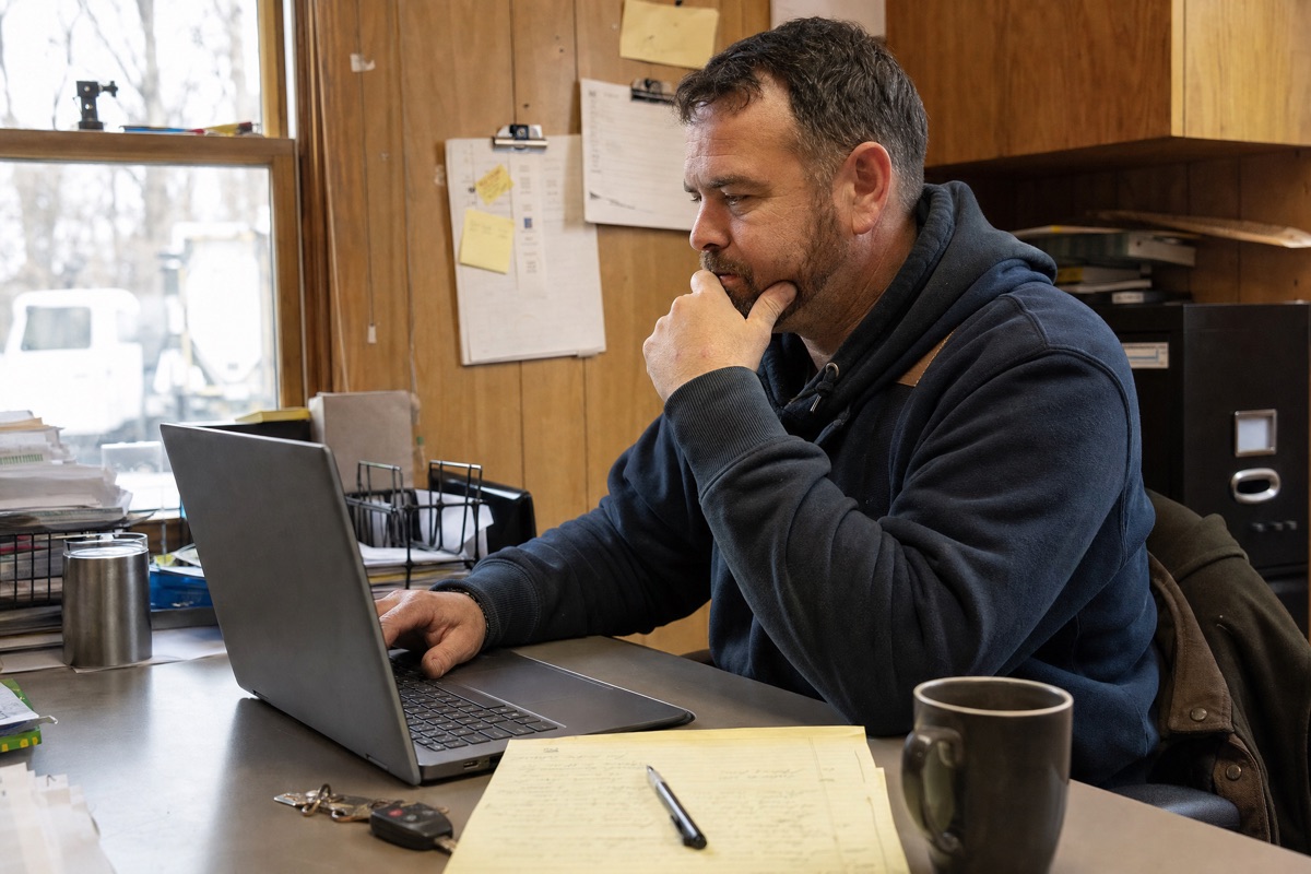 A contractor reviewing where his leads came from on a laptop in the office